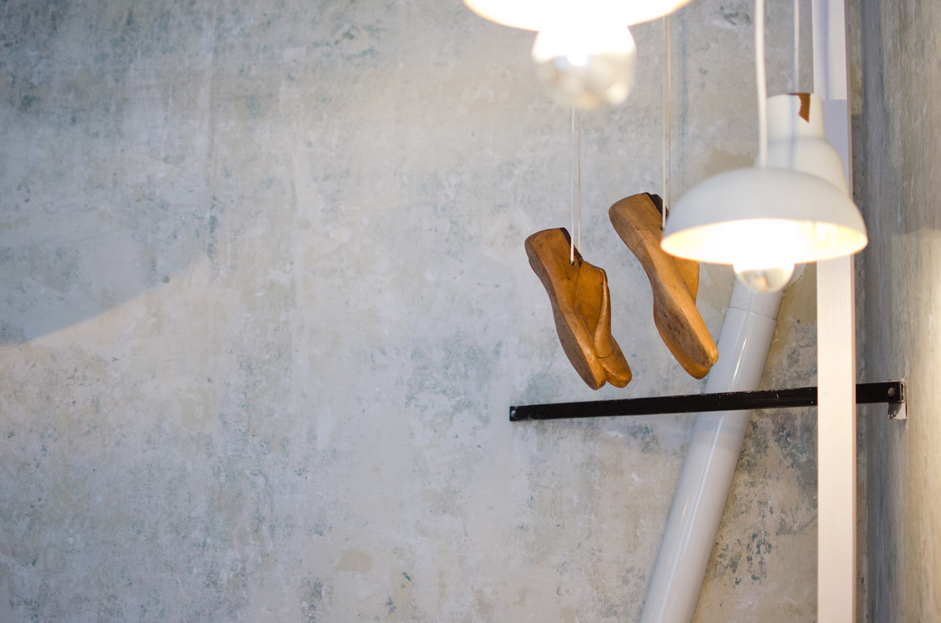 Schuhvorlagen aus Holz hängen von der Decke im Atelier der Schusterin