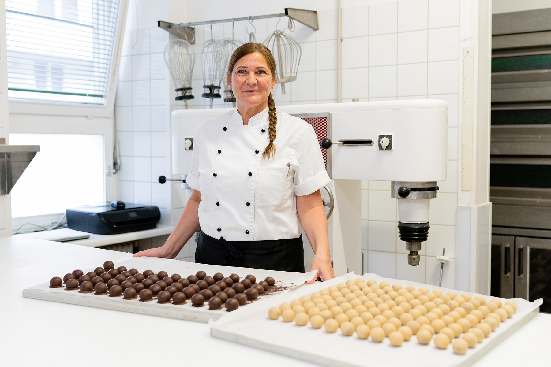 Monika Zehetner steht in der Backstube vor zwei Bleche voll mit Kugeln