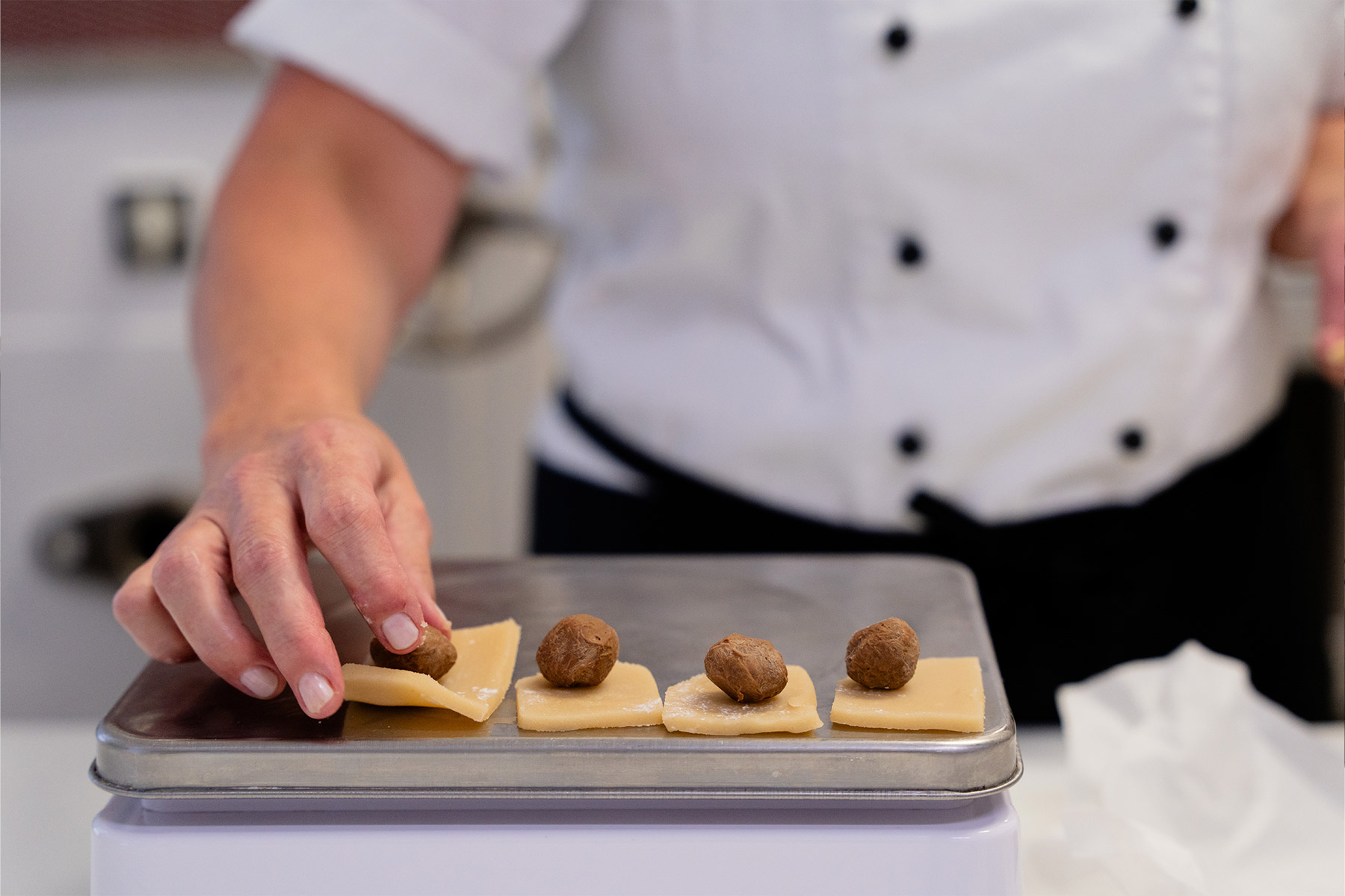 Die Hände von Monika wiegen das Marzipan ab