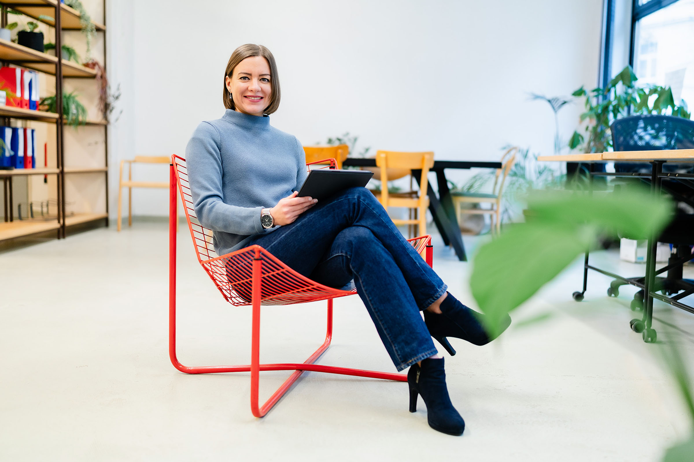 Katharina sitzt in einem Sessel mit ihrem Tablet