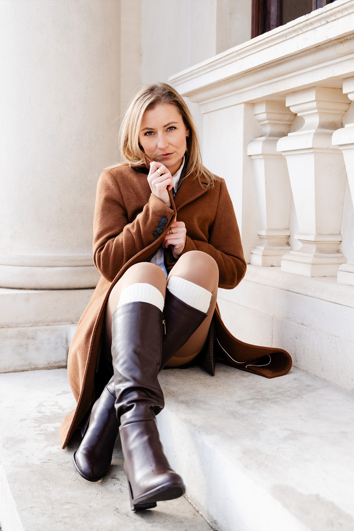 Katja schmiegt sich in ihren braunen Mantel