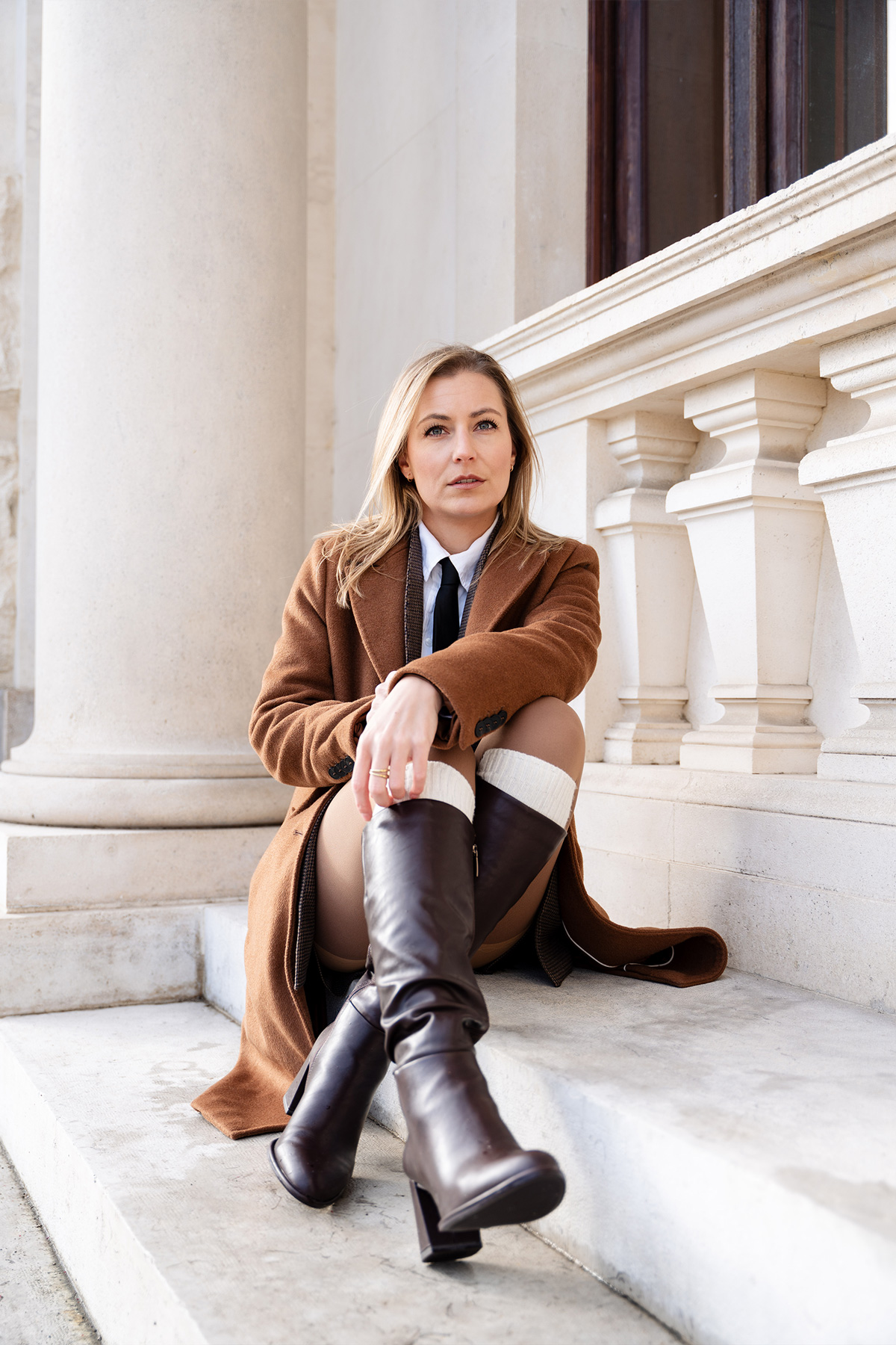 Katja sitzt auf den Stufen und schaut in die Ferne