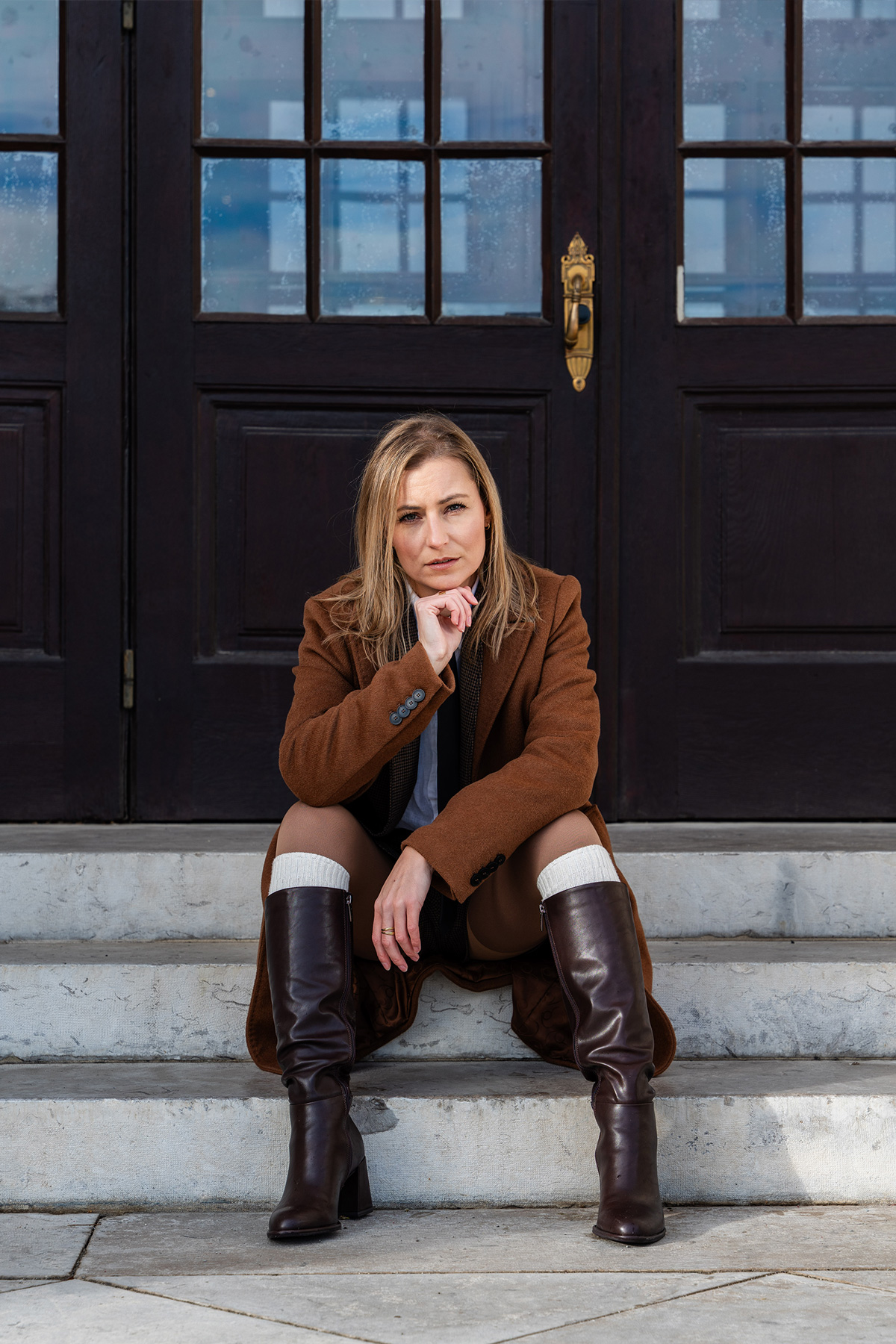 Katja schaut ernst auf den Stufen sitzend