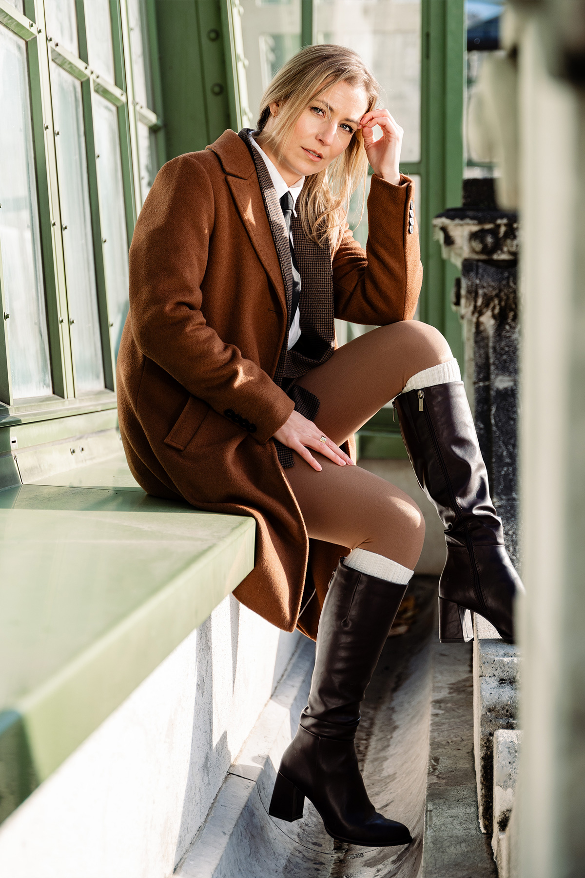 Katja sitzt beim Schmetterlingshaus und schaut in die Kamera