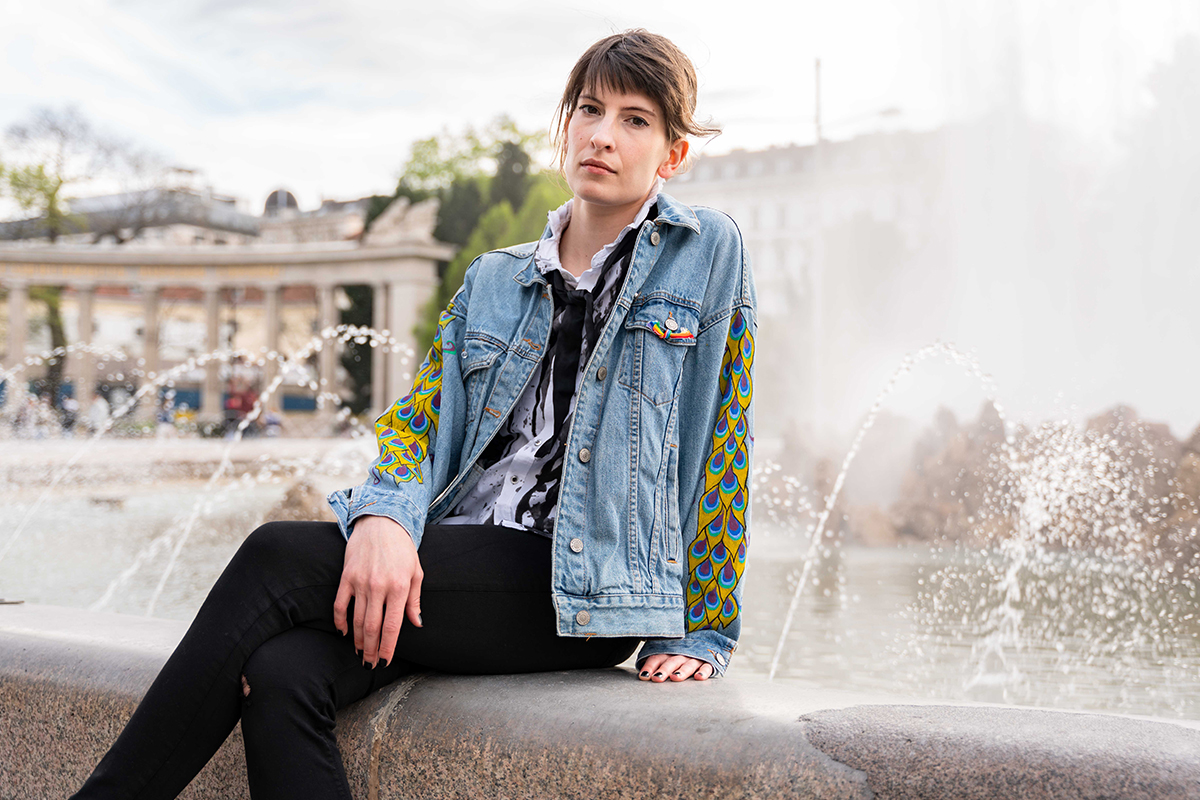 bemalte Jeansjackenärmel vor Springbrunnen am Schwarzenbergplatz