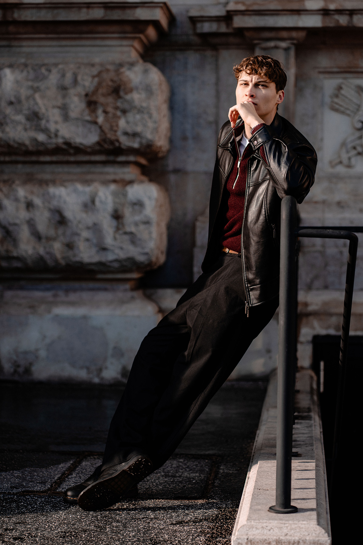 Tobi sieht ernst in die Kamera, an ein Stiegengeländer gelehnt