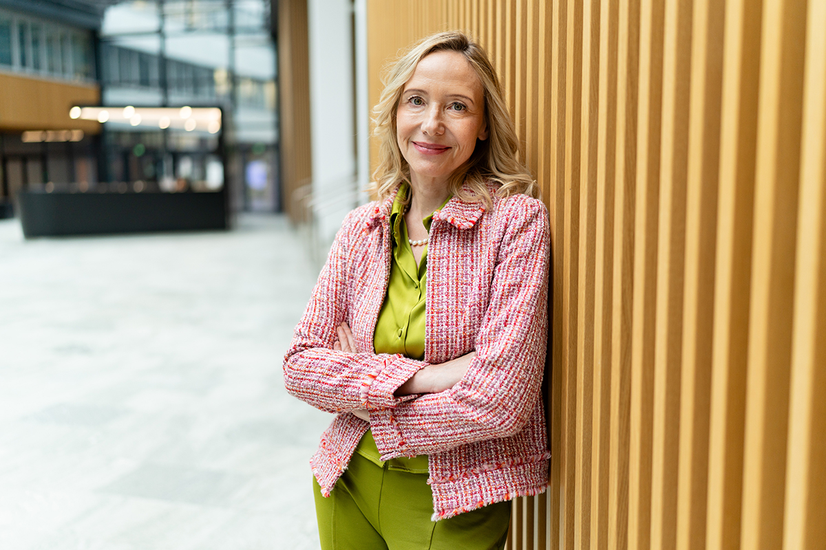 Alexandra Graf lehnt an der Holzwand in der Empfangshalle