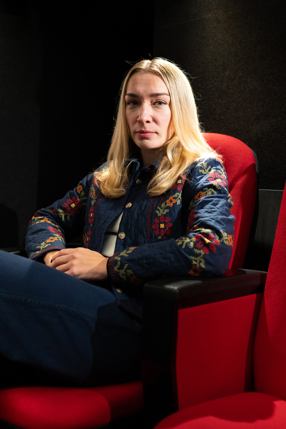 Inna Shevchenko sitzt im Kinosessel, ihr Gesicht halb im Schatten, halb im Licht der kleinen Lampe über ihr