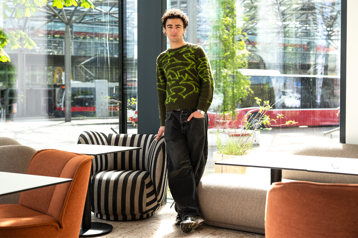Der junge Künstler Cosmó steht im Café Engländer und schaut in die Kamera