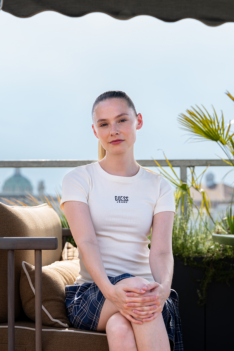 Esther sitzt unter dem Sonnenschirm