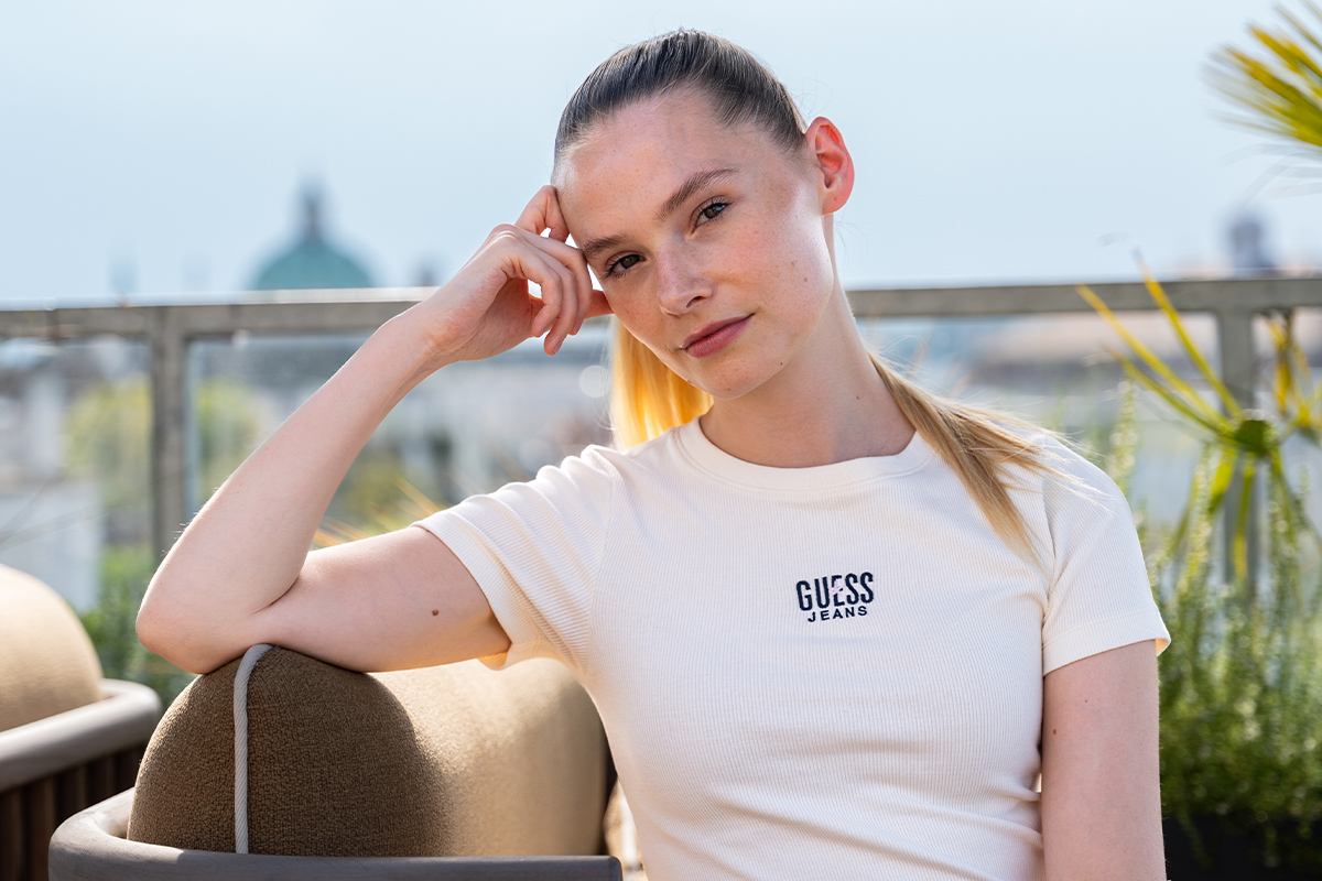 Esther schaut mit verträumten Blick in die Kamera, im Hintergrund der Turm der Karlskirche